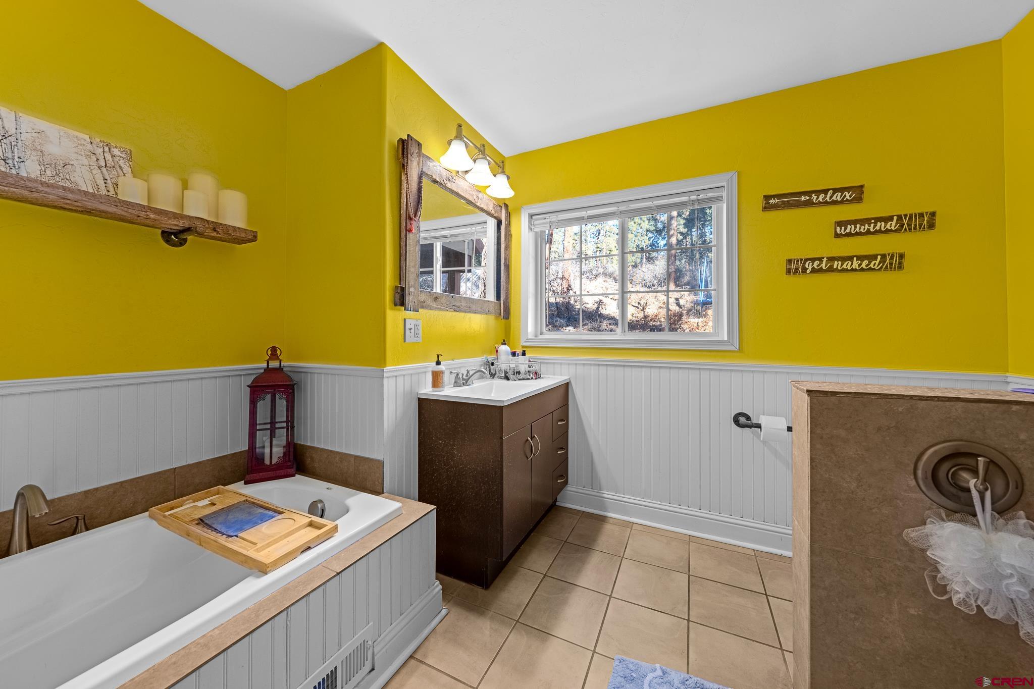 700 Blue Ridge Drive Bayfield, CO 81122 - Photo 20 of 30 a bathroom with a tub sink and mirror