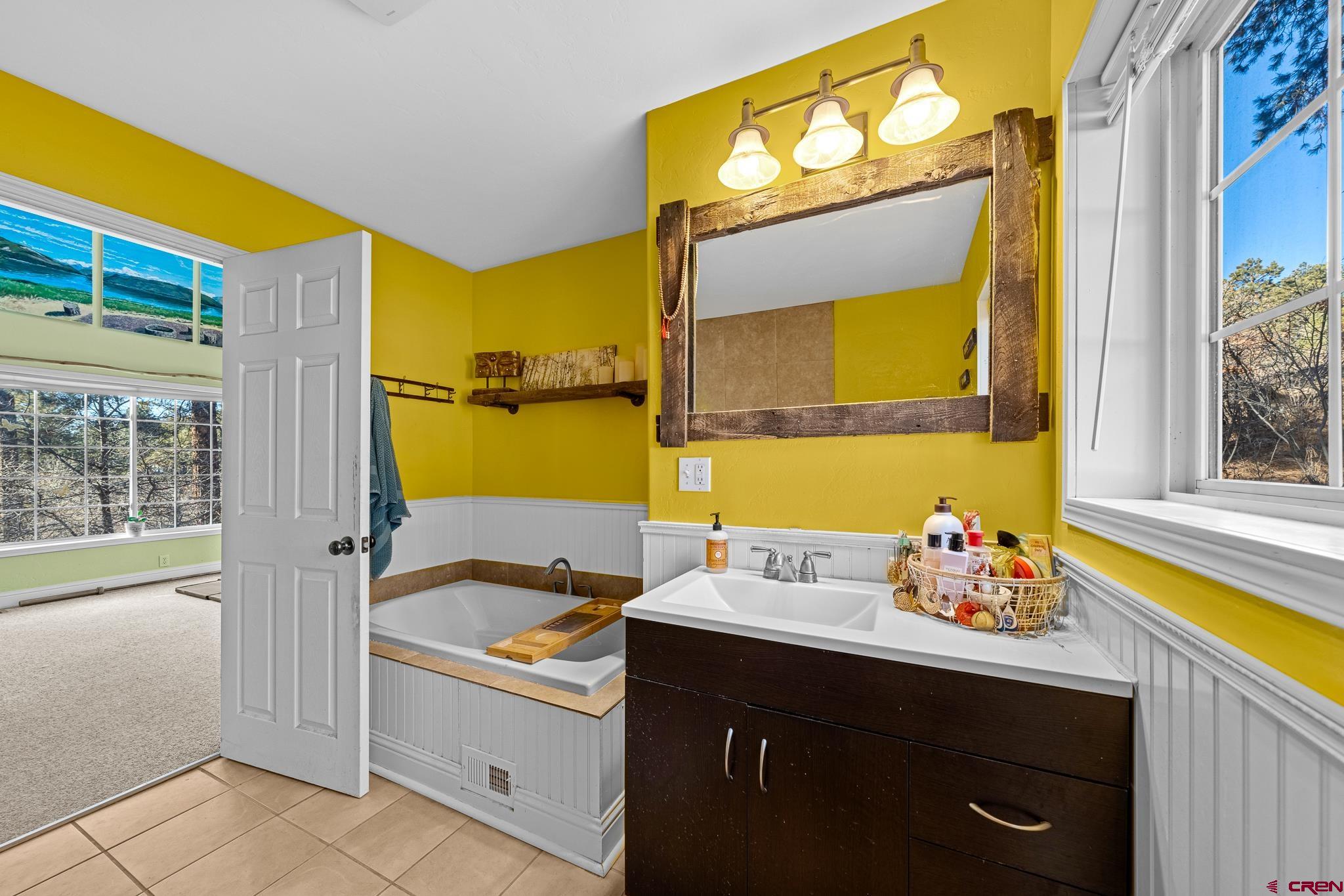 700 Blue Ridge Drive Bayfield, CO 81122 - Photo 21 of 30 a bathroom with a sink mirror and a bathtub