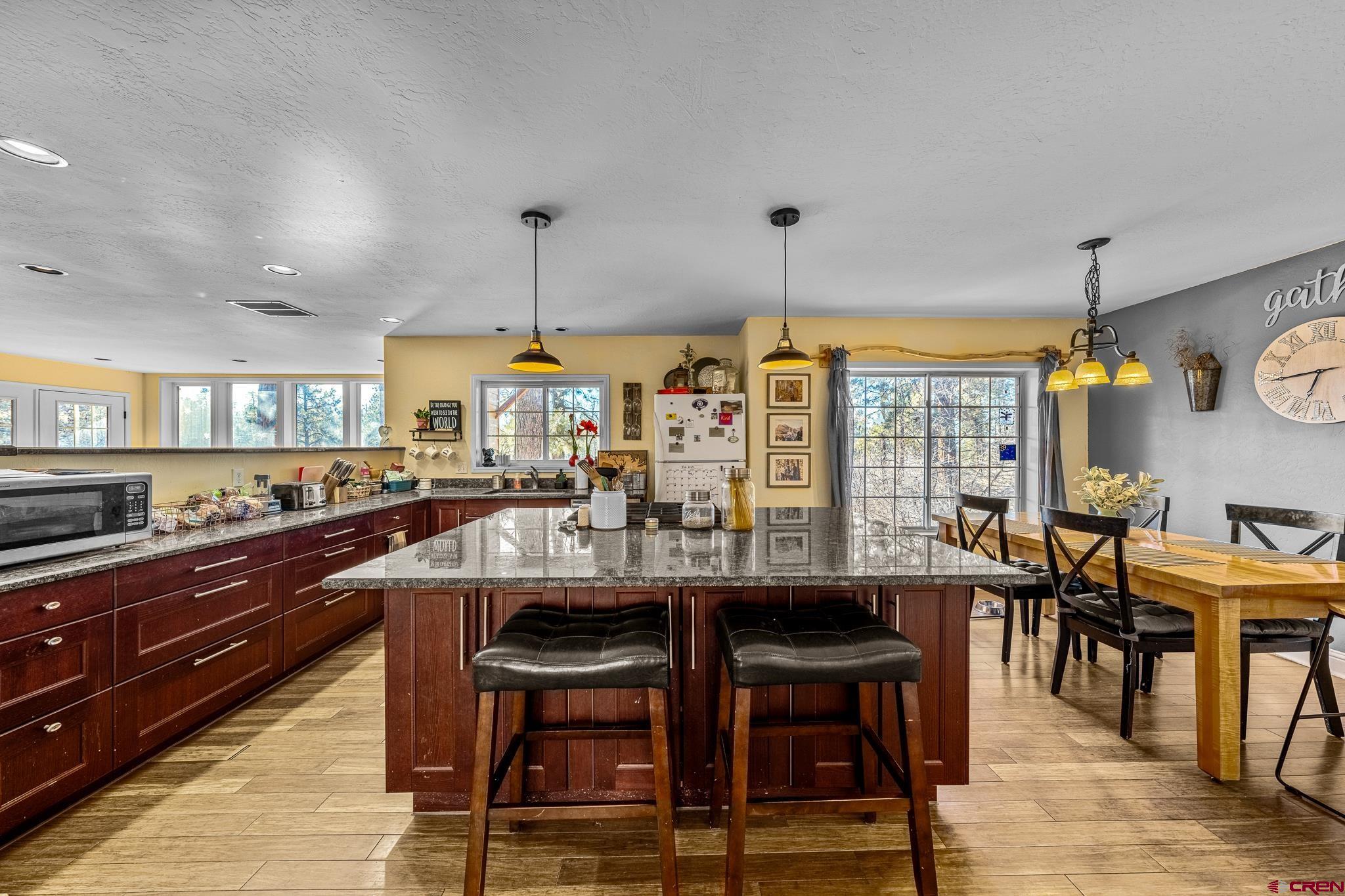 700 Blue Ridge Drive Bayfield, CO 81122 - Photo 9 of 30 a kitchen with stainless steel appliances kitchen island granite countertop a table chairs sink and wooden floor