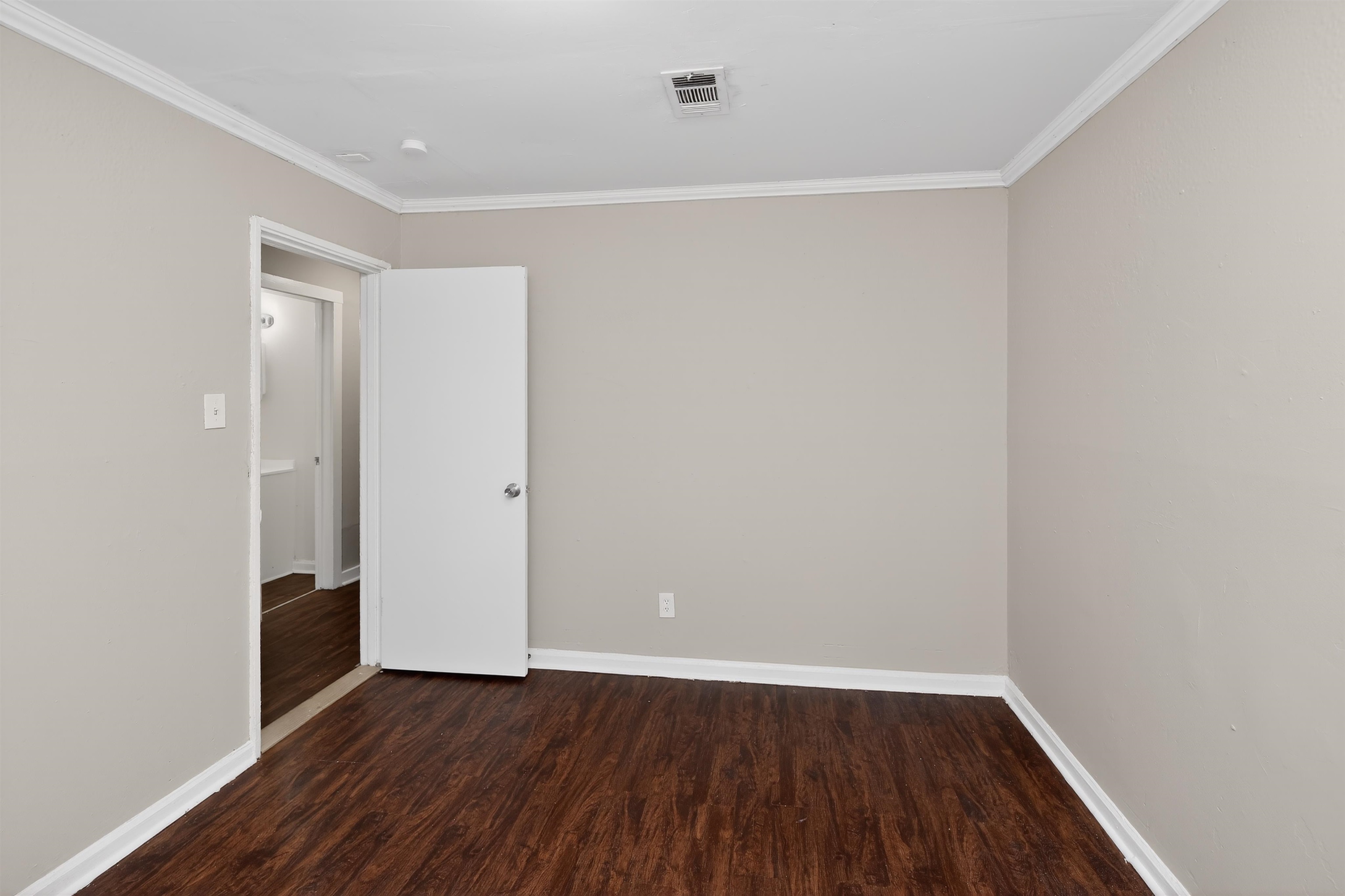 4838 Manson Road Memphis, TN 38109 - Photo 12 of 28 Room featuring wood-finish flooring, light neutral wall paint, white baseboards, and white crown molding