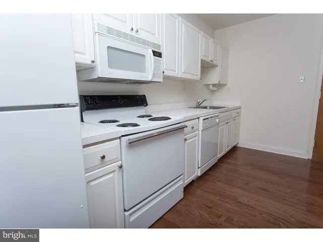 a kitchen with stainless steel appliances a stove microwave and sink