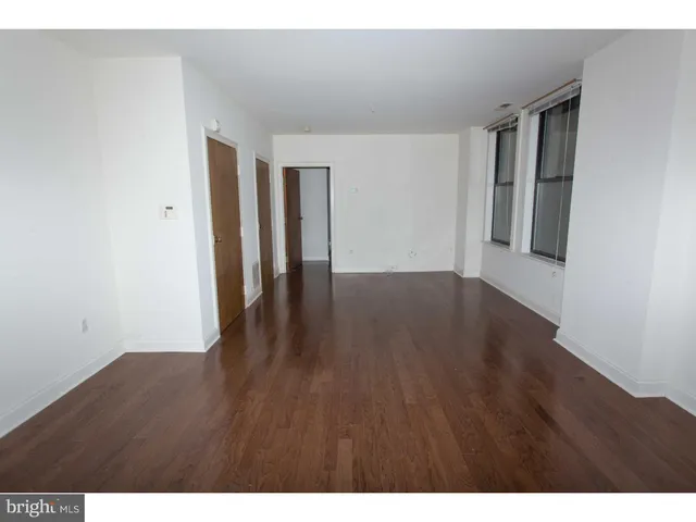 a view of an empty room with wooden floor