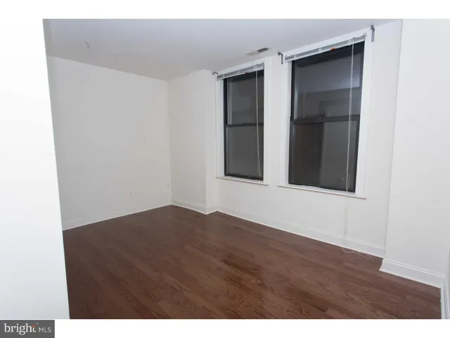 a view of an empty room with closet and a window