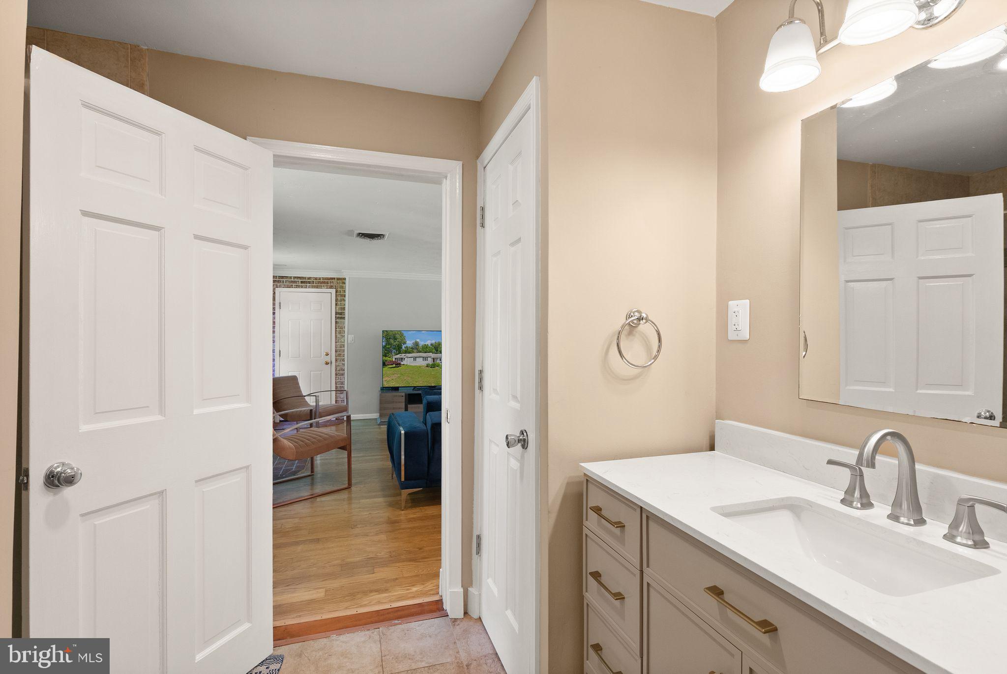 815 Seneca Road Great Falls, VA 22066 - Photo 40 of 61 a en suite bathroom with a granite countertop sink and a mirror