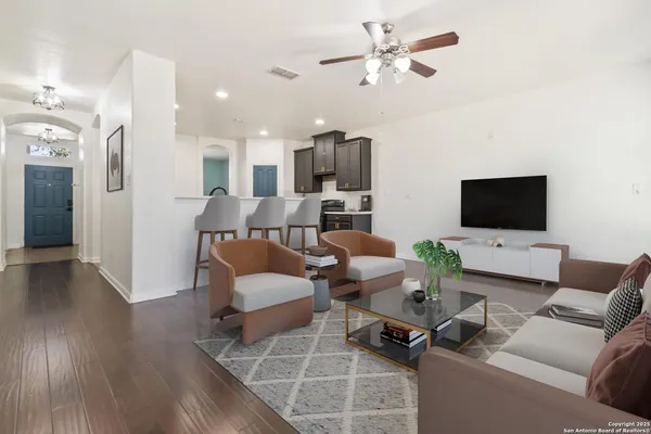 a living room with furniture a flat screen tv and kitchen view