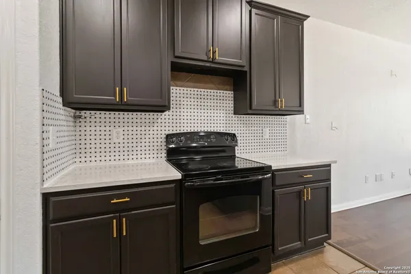 a kitchen with wooden cabinets and a stove top oven
