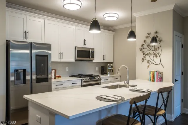 a kitchen with stainless steel appliances a table chairs and a refrigerator