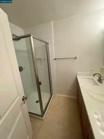 a bathroom with a sink and mirror with shower