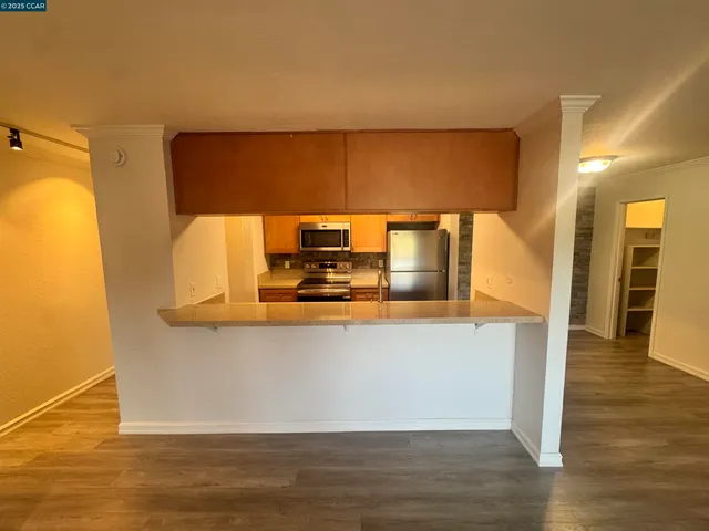 a view of a kitchen with wooden floor and a sink