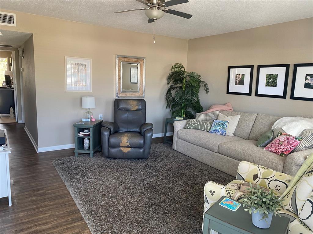 8455 112th Street North, Unit 212 Seminole, FL 33772 - Photo 2 of 21 a living room with furniture and a wooden floor