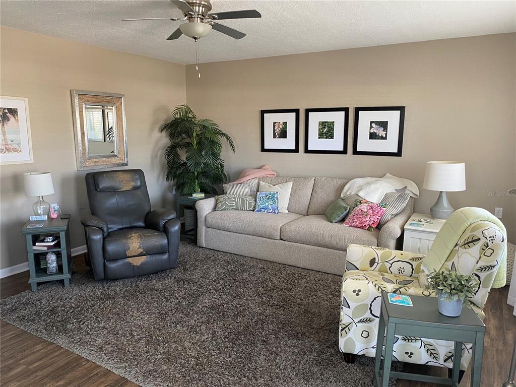 8455 112th Street North, Unit 212 Seminole, FL 33772 - Photo 3 of 21 a living room with furniture and a chandelier