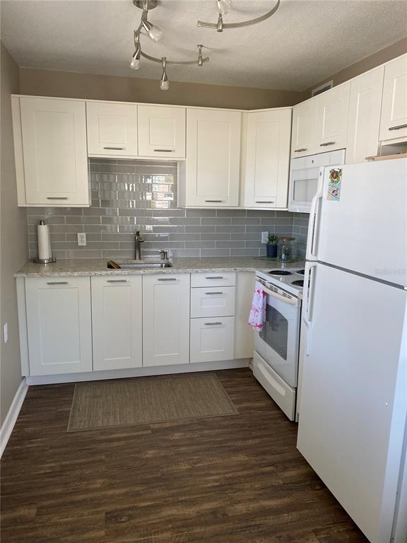 8455 112th Street North, Unit 212 Seminole, FL 33772 - Photo 4 of 21 a kitchen with stainless steel appliances granite countertop a stove a sink dishwasher and a refrigerator with wooden floor