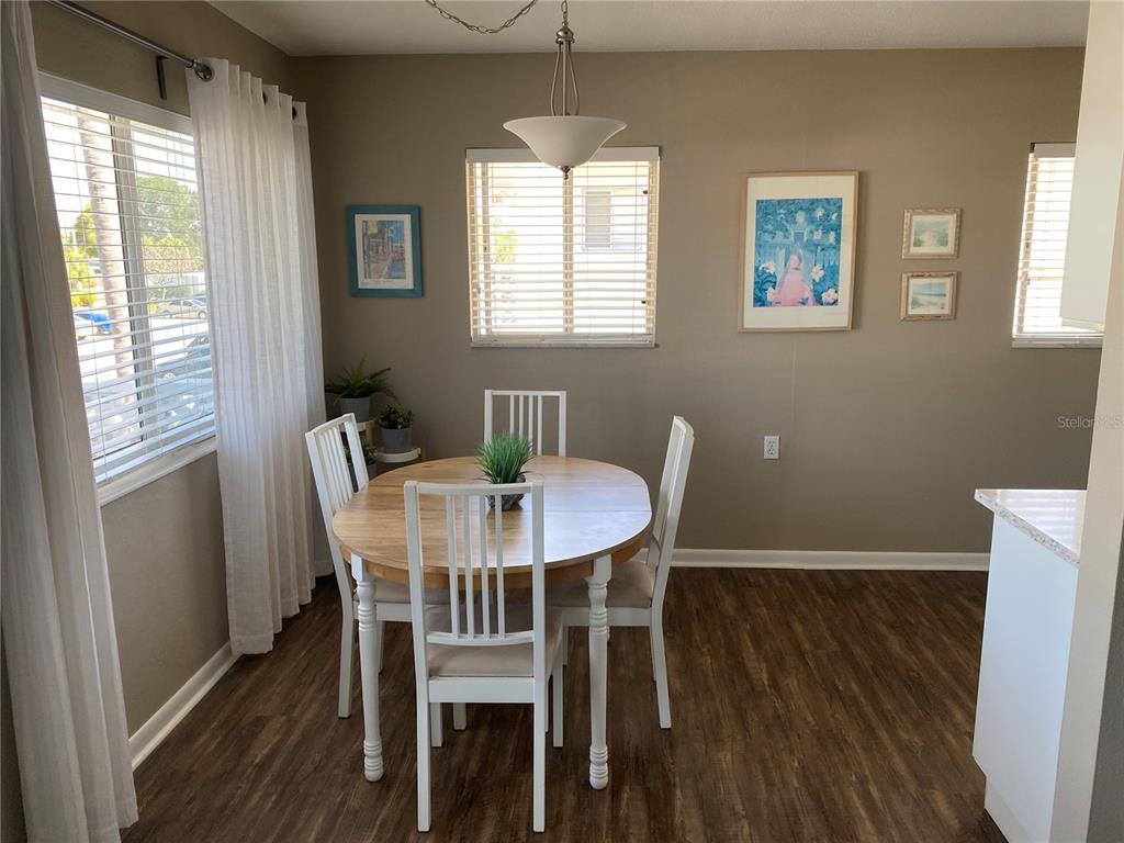 8455 112th Street North, Unit 212 Seminole, FL 33772 - Photo 6 of 21 a view of a dining room with furniture window and wooden floor