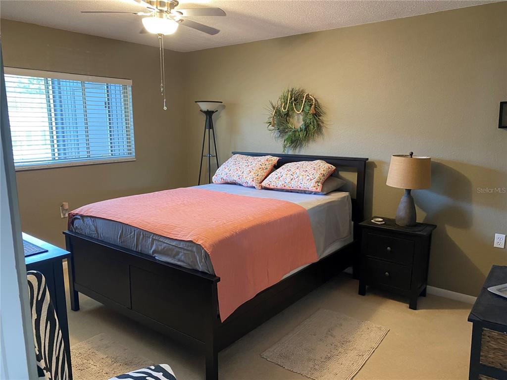 8455 112th Street North, Unit 212 Seminole, FL 33772 - Photo 7 of 21 a bedroom with a bed and a chandelier
