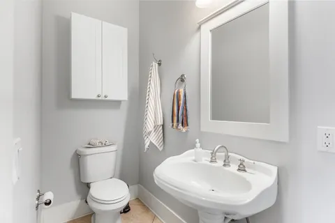 a bathroom with a sink a toilet and a mirror