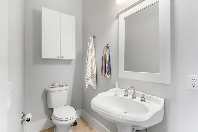 a bathroom with a sink a toilet and a mirror