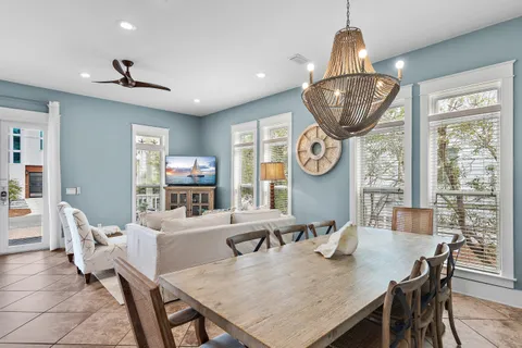 a view of a white house with a large windows and a yard with palm trees