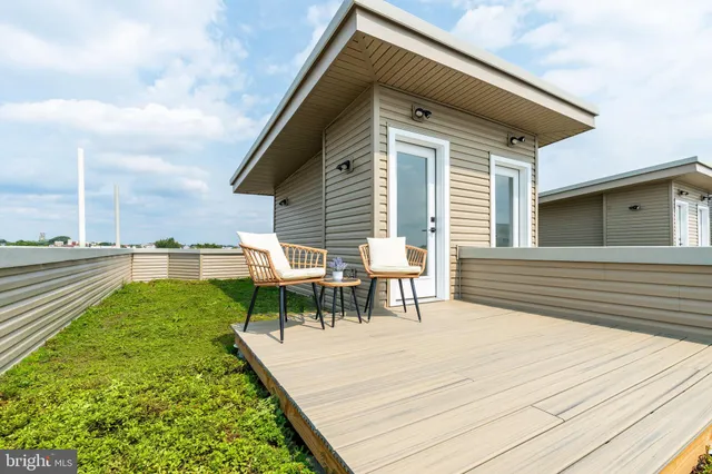 a view of a chairs and table on wooden deck with a yard