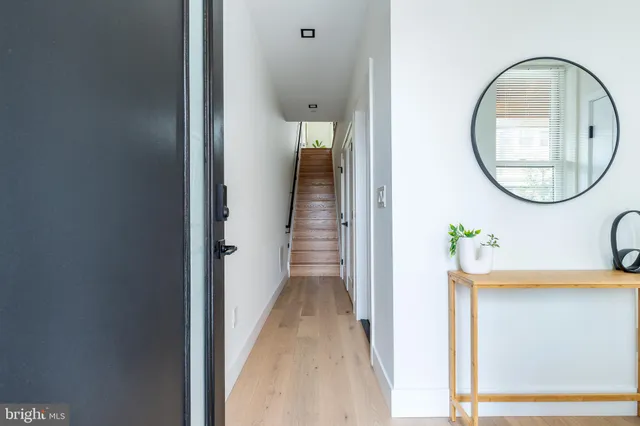a living room with furniture large window and wooden floor