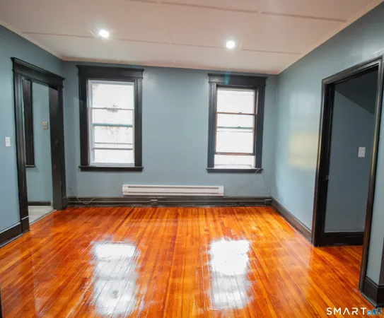 an empty room with wooden floor and a window
