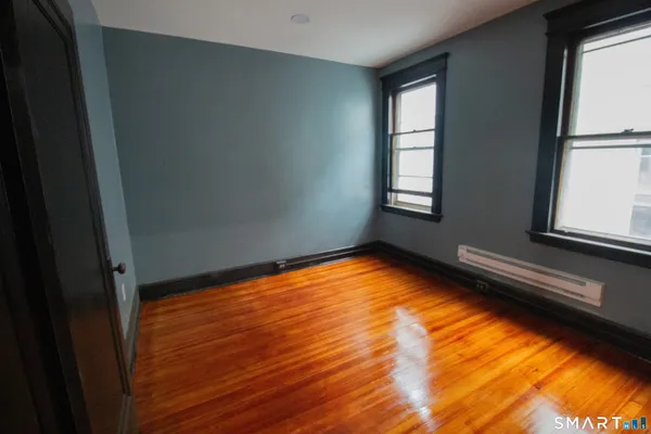 a view of an empty room with wooden floor