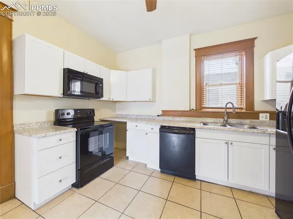 a kitchen with granite countertop a sink cabinets and stainless steel appliances