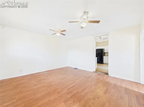 a view of a room with wooden floor and white walls