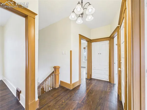 a view of a hallway with wooden floor and staircase