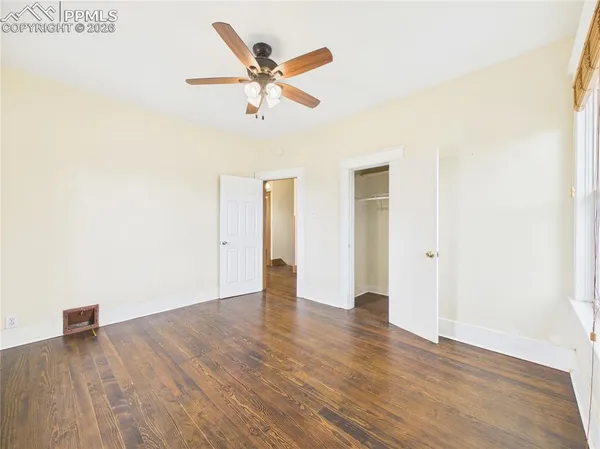 a view of a big room with wooden floor and windows