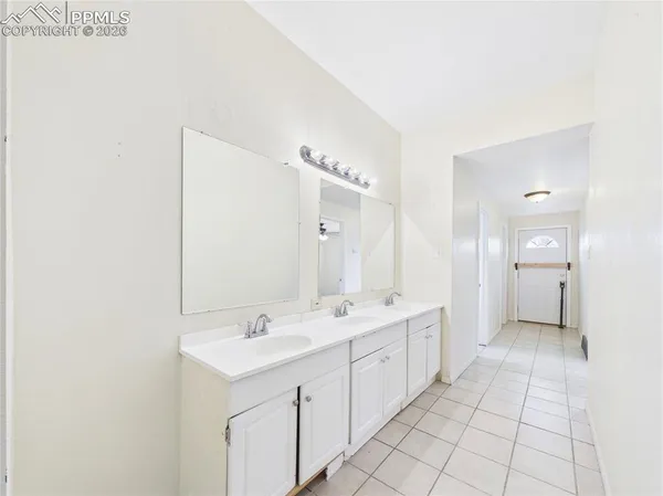 a spacious bathroom with a double vanity sink a mirror and a bathtub