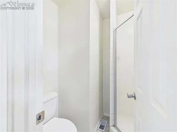 a bathroom with a toilet and a shower