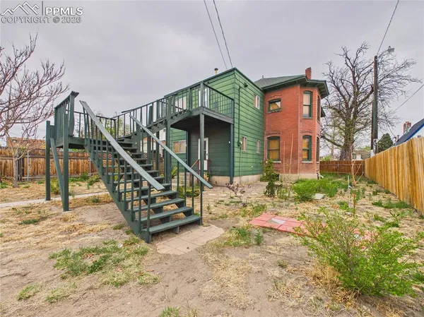 a backyard of a house with table and chairs