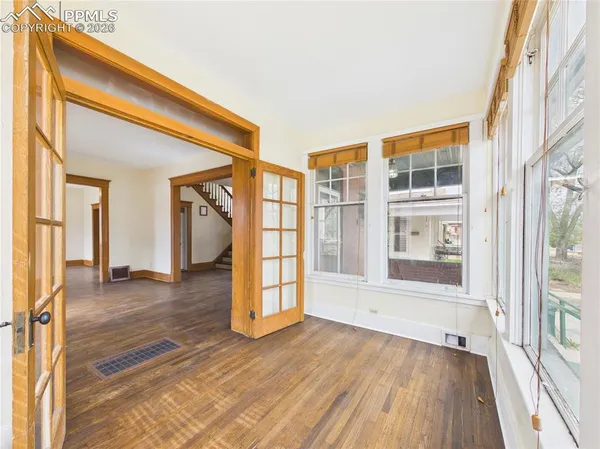 a view of a big room with wooden floor and windows