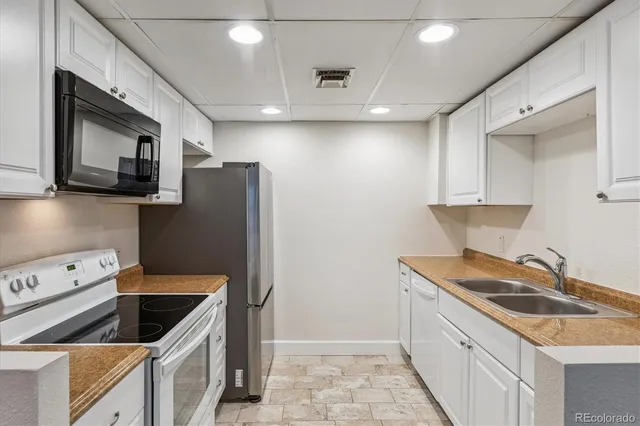 a kitchen with stainless steel appliances granite countertop a refrigerator a stove top oven a sink and dishwasher