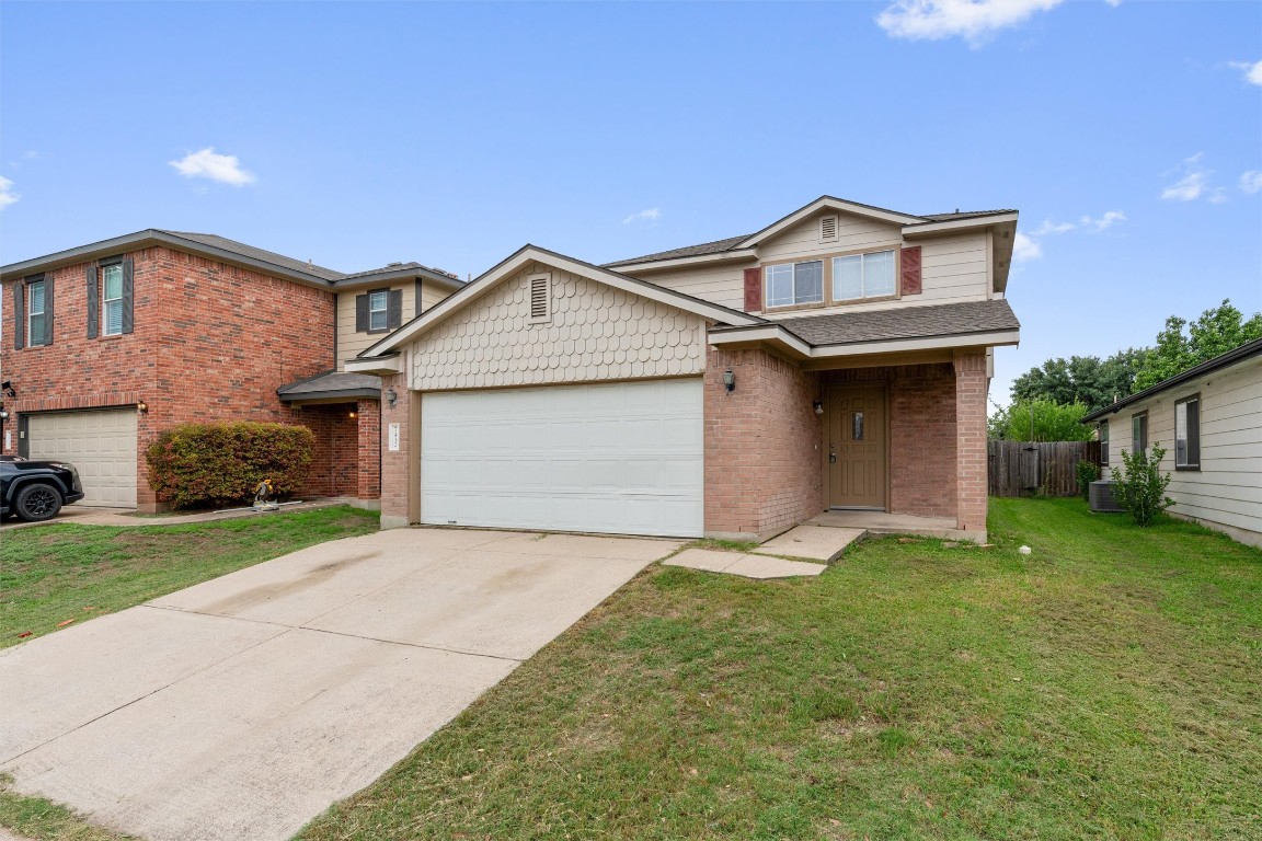 a front view of a house with a yard and garage