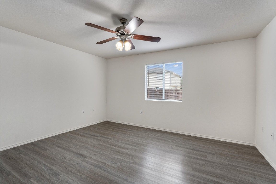 7432 Cayenne Lane Austin, TX 78741 - Photo 12 of 30 a view of an empty room with wooden floor and a fan