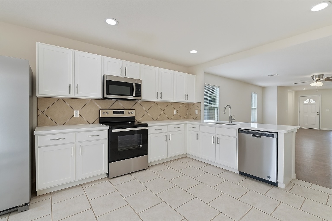 7432 Cayenne Lane Austin, TX 78741 - Photo 2 of 30 a kitchen with granite countertop white cabinets and stainless steel appliances