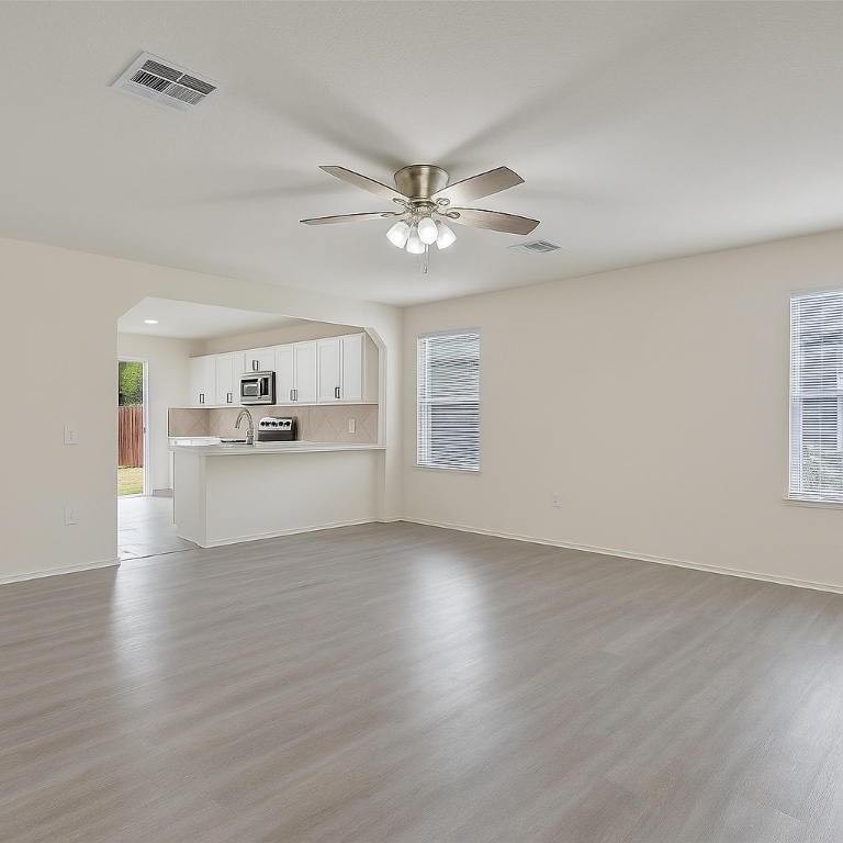 7432 Cayenne Lane Austin, TX 78741 - Photo 5 of 30 a view of a livingroom with a kitchen stove wooden cabinets and wooden floor