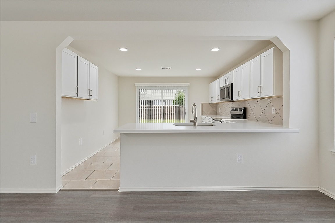 7432 Cayenne Lane Austin, TX 78741 - Photo 6 of 30 a kitchen with stainless steel appliances granite countertop a sink a stove and a refrigerator