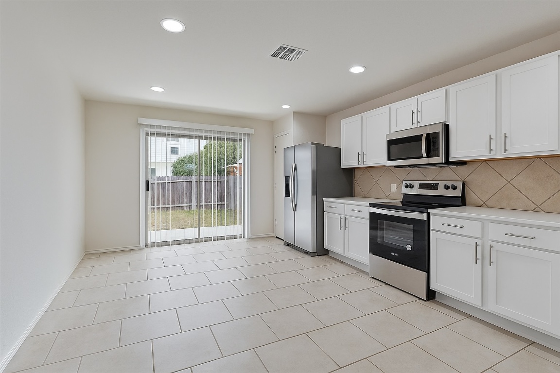 7432 Cayenne Lane Austin, TX 78741 - Photo 7 of 30 a kitchen with granite countertop a refrigerator and a stove top oven