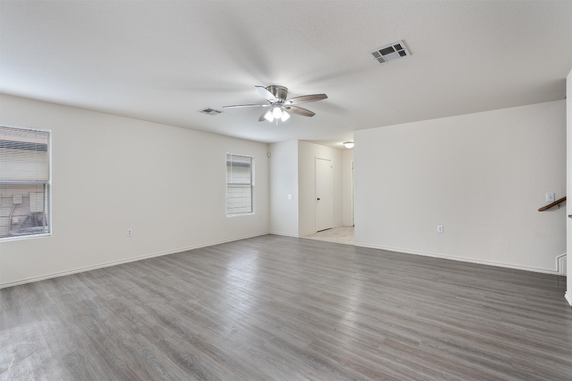 7432 Cayenne Lane Austin, TX 78741 - Photo 10 of 30 a view of an empty room with wooden floor and a ceiling fan