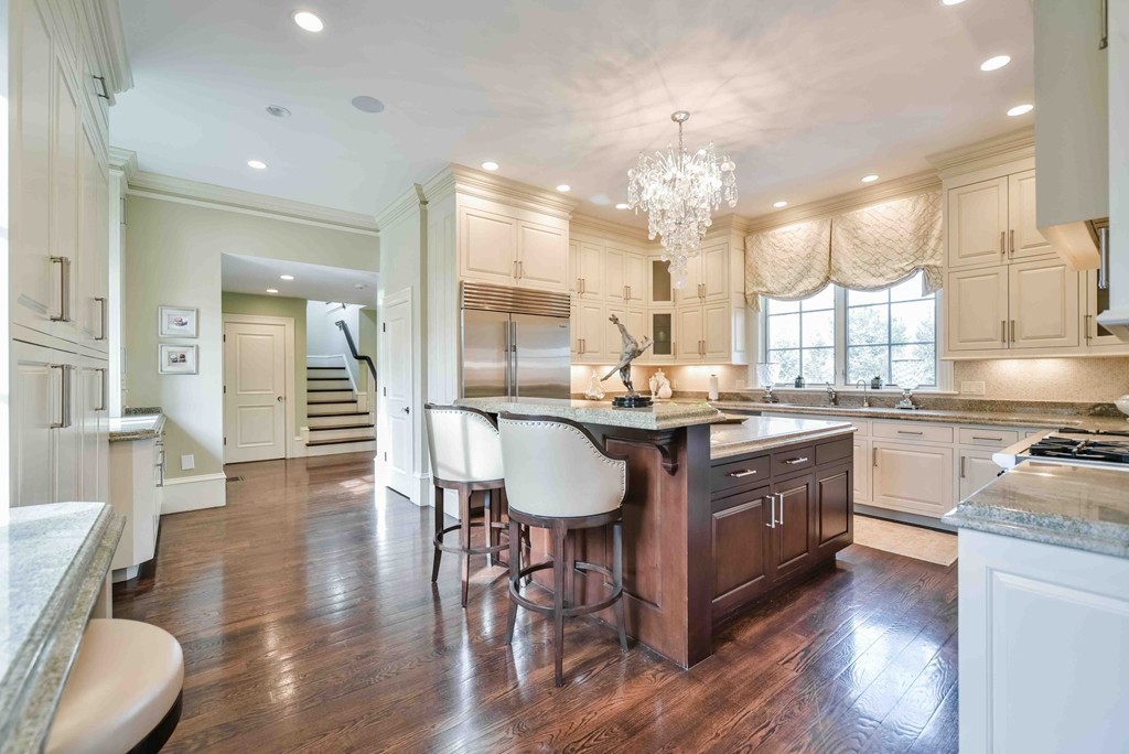 458 Heath Street Brookline, MA 02467 - Photo 9 of 28 a kitchen with stainless steel appliances granite countertop a kitchen island a stove a sink a dining table and chairs