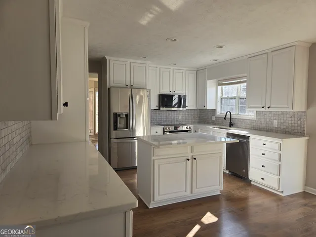 a kitchen with white cabinets and stainless steel appliances