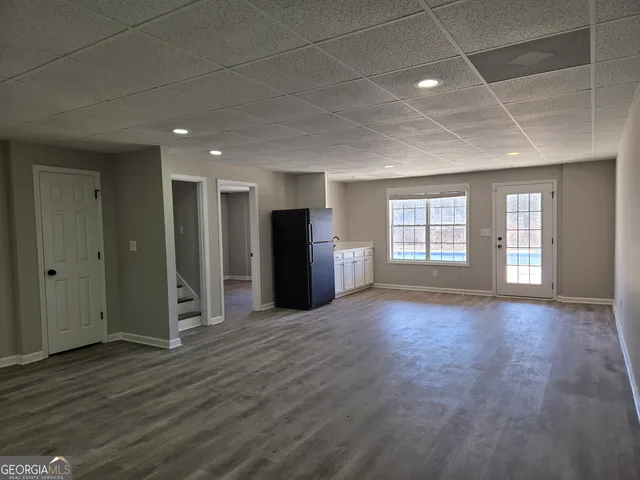 a view of an empty room with window and wooden floor