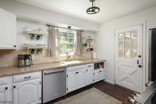 a kitchen with stainless steel appliances granite countertop a sink a stove and cabinets