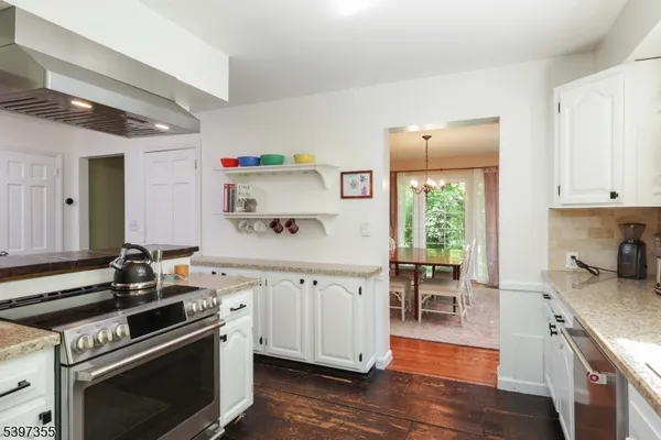 a kitchen with a stove sink and wooden floor