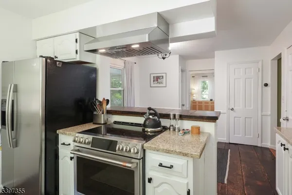 a kitchen with stainless steel appliances granite countertop a refrigerator and a stove
