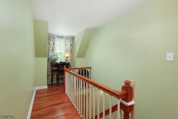 a view of a hallway with wooden floor and stairs