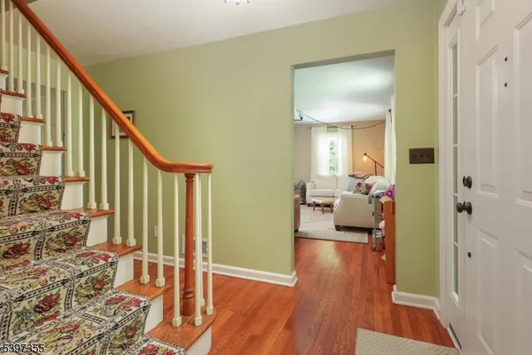 a view of a hallway view with living room and wooden floor