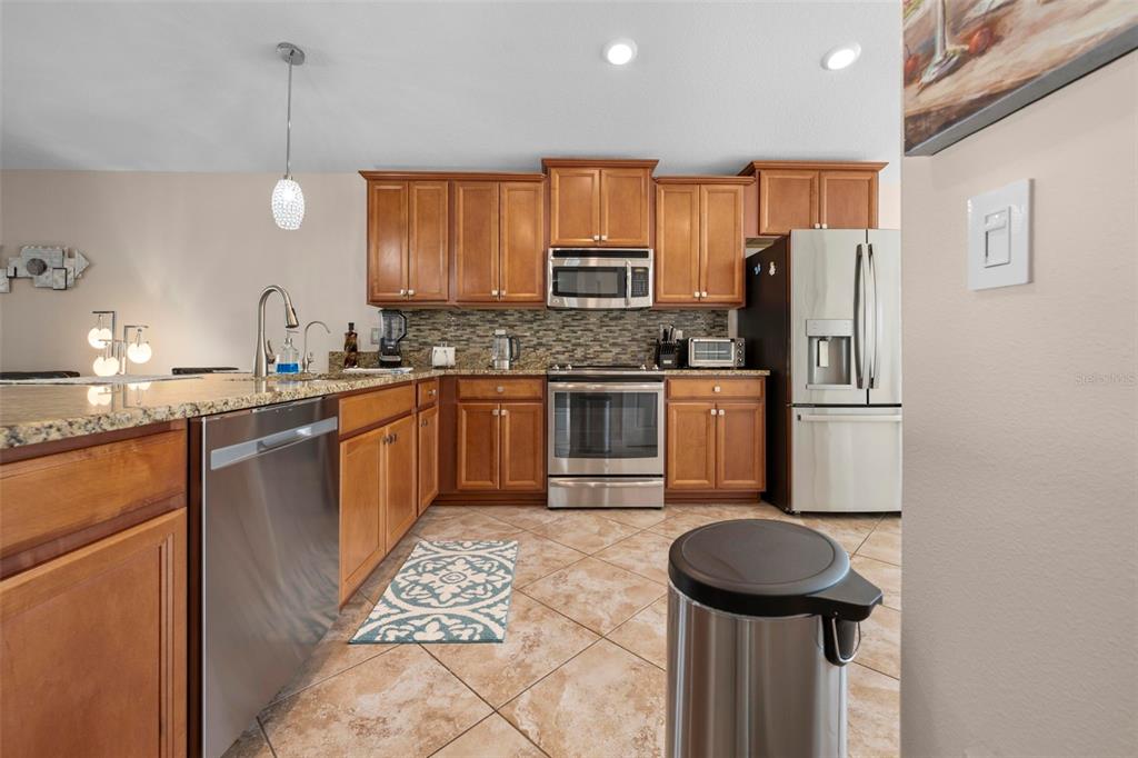 10114 Ives Loop Hudson, FL 34667 - Photo 16 of 49 a kitchen with stainless steel appliances a sink stove and refrigerator